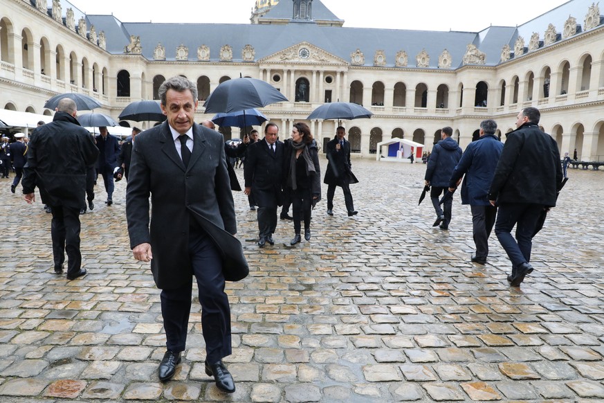 epa06634179 Former French President Nicolas Sarkozy (L) and former French President Francois Hollande (Rear C-L) leave following a national ceremony for Lieutenant-Colonel Arnaud Beltrame, at the Hote ...