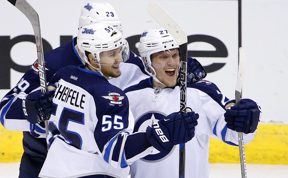 Winnipeg Jets right wing Nikolaj Ehlers (27) celebrates his goal against the Arizona Coyotes with center Mark Scheifele (55) and right wing Patrik Laine (29) during the third period of an NHL hockey g ...