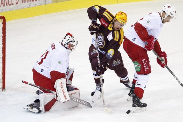 Geneve-Servette&#039;s center Tanner Richard, center, vies for the puck with Lausanne&#039;s defender Petteri Lindbohm, of Finland, right, past Lausanne&#039;s goaltender Sandro Zurkirchen, left, duri ...