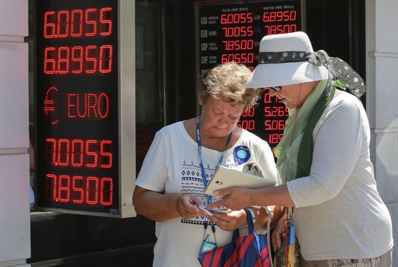 Tourists count their Turkish liras after exchanging foreign currency at a exchange shop in Istanbul, Monday, Aug. 13, 2018. Turkey&#039;s central bank announced a series of measures on Monday to free  ...