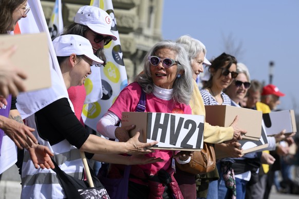 Personen uebergeben die Schachteln mit Unterschriften, waehrend die uebergabe der Unterschriften fuer das Referendum gegen die AHV-Reform, am Freitag, 25. Maerz 2022, vor der Bundeskanzlei, in Bern. ( ...