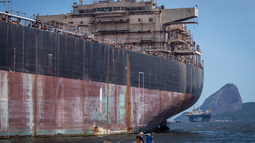 epa10334136 Fishermen work next to an oil tanker in Guanabara Bay, in Niteroi, near Rio de Janeiro, Brazil, on 21 November 2022 (issued 28 November 2022). The Guanabara Bay, which bathes Rio de Janeir ...