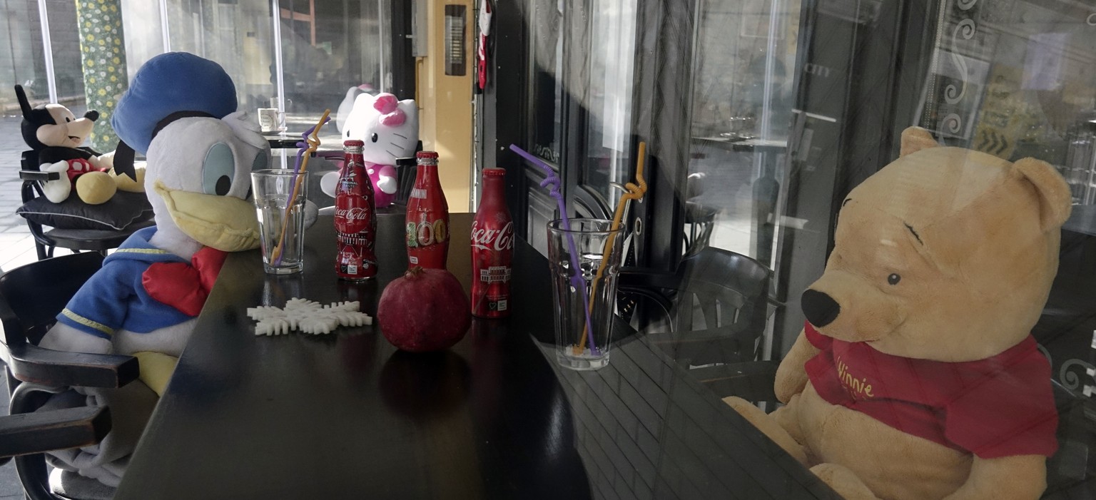 Cuddly toys sit in a closed cafe in the capital Sarajevo, Bosnia, Saturday, March 13, 2021. All non-essential shops, bars and restaurants closed over the weekend in Bosnia and Herzegovina and Serbia d ...