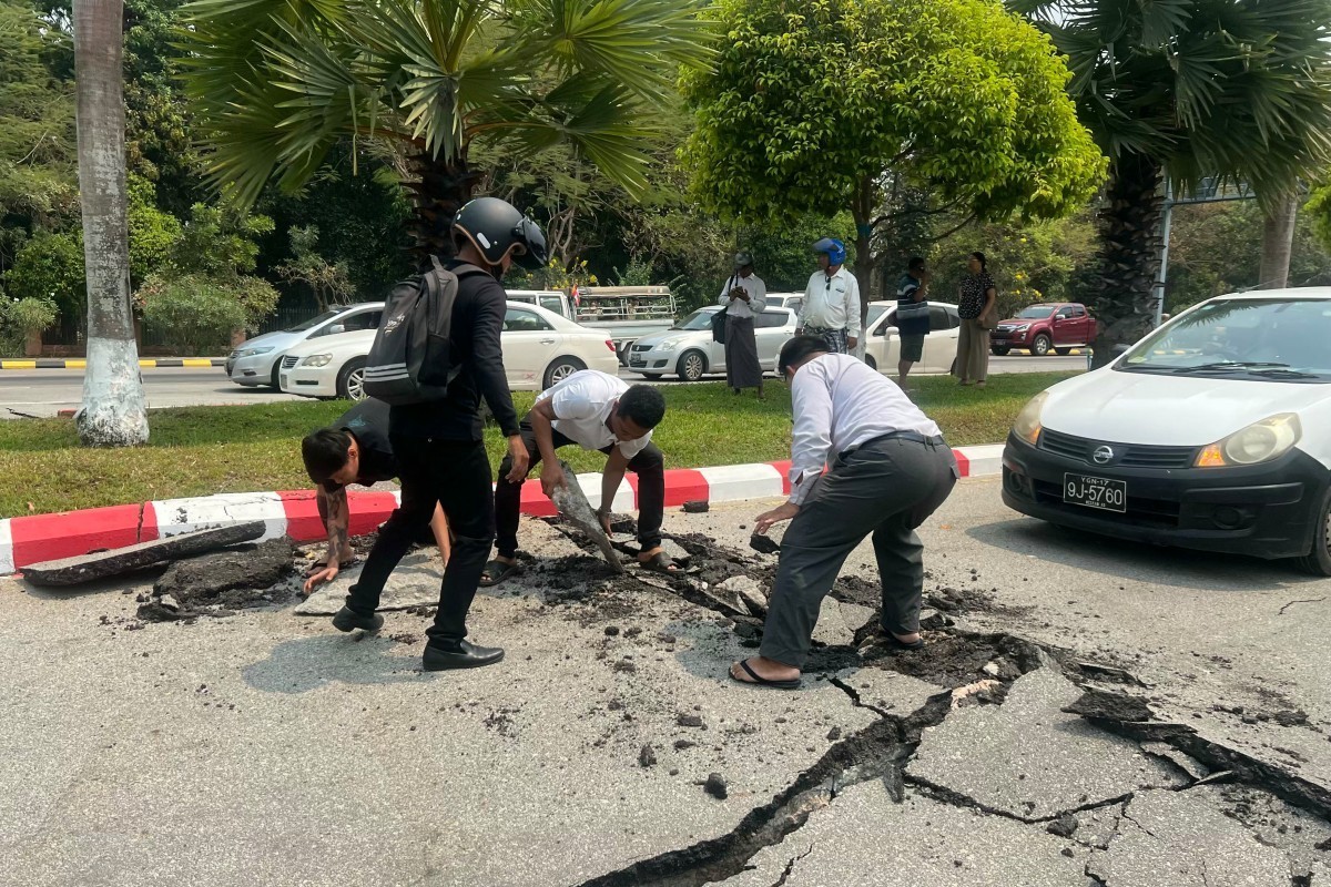 Motorists pick up pieces of a damaged road in Naypyidaw on March 28, 2025, after an earthquake in central Myanmar. A powerful earthquake rocked central Myanmar on March 28, buckling roads in capital N ...