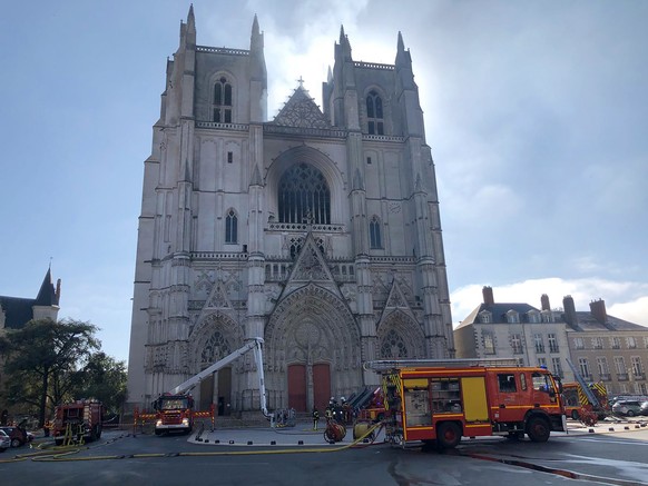 FILE - In this July 18, 2020, file photo, fire fighters brigade work to extinguish the blaze at the Gothic St. Peter and St. Paul Cathedral, in Nantes, western France. French authorities detained and  ...