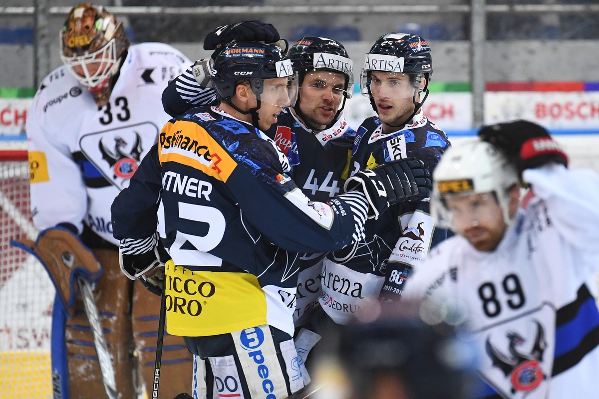 Ambri's Cory Emmerton celebrates with teammates Diego Kostner and Nick Plastino, from right, the 4-3 goal, during the preliminary round game of National League Swiss Championship between HC Ambri ...