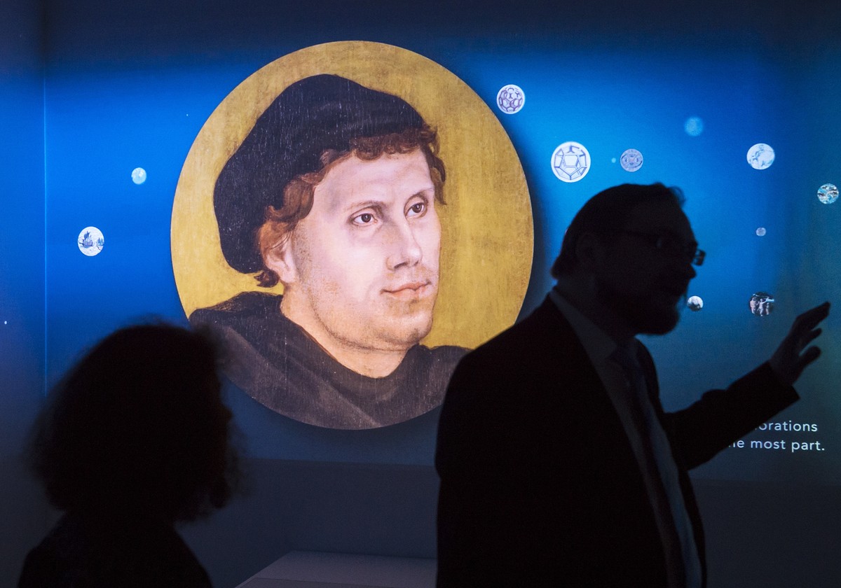 Visitors stand in front of a video installation displaying a portrait of Martin Luther during the press preview of the exhibition '95 Treasures – 95 People' in the Augusteum in Wittenberg, G ...