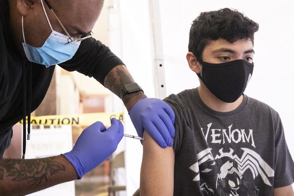 epa09156038 Joel, an 18-year-old student, receives a shot of COVID-19 vaccine during a vaccination drive organized by St. John&#039;s Well Child and Family at the Abraham Lincoln High School in Los An ...