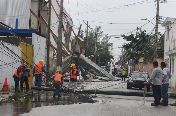 epa08779366 Workers clear the debris after the passage of Hurricane Zeta, in the resort of Cancu, state of Quintata Roo, Mexico, 27 October 2020. The Mexican Caribbean suffered the impact of Hurricane ...