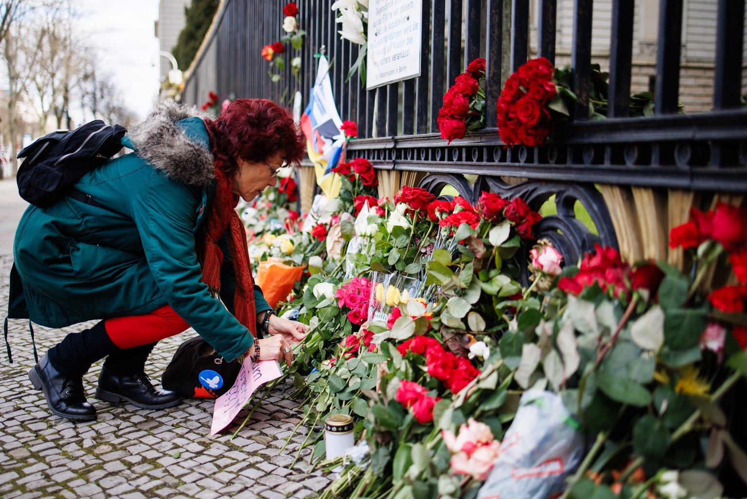 epa11243126 A mourner lays flowers in memory of the victims of the terrorist attack on the Crocus City Hall in Krasnogorsk at the Russian embassy in Berlin, Germany, 25 March 2024. At least 137 people ...