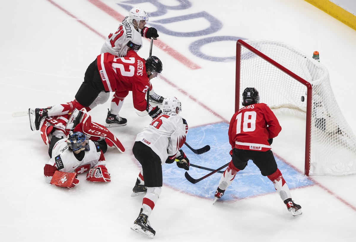Canada's Dylan Cozens (22) scores a goal on Switzerland goalie Noah Patenaude (1) during the second period of an IIHF World Junior Hockey Championship game Tuesday, Dec. 29, 2020, in Edmonton, Al ...