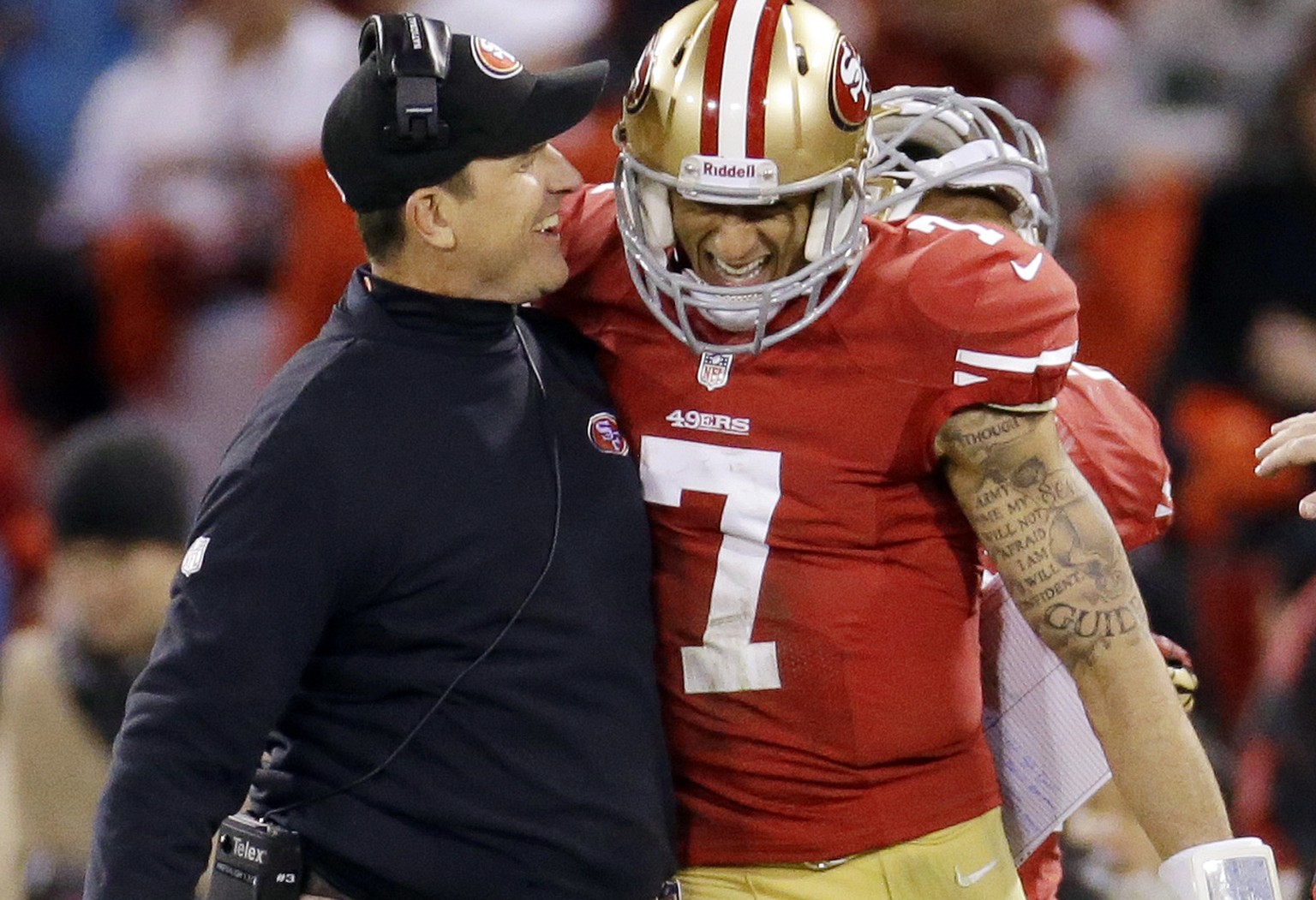San Francisco 49ers head coach Jim Harbaugh celebrates with quarterback Colin Kaepernick (7) after Kaepernick's 56-yard touchdown run against the Green Bay Packers during the third quarter of an NFC d ...