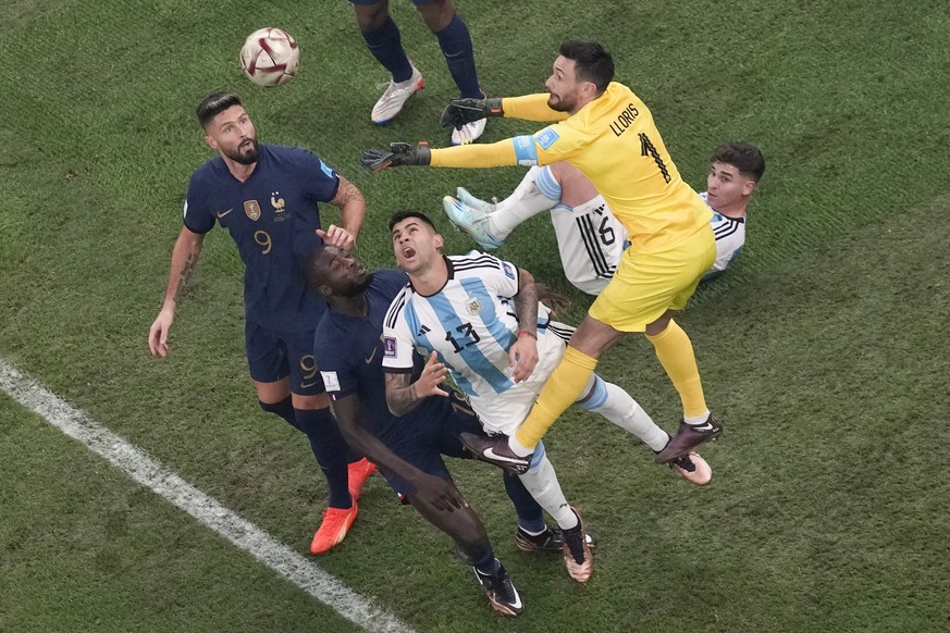 France&#039;s goalkeeper Hugo Lloris saves as Argentina&#039;s Cristian Romero, with number 13, tries to head the ball during the World Cup final soccer match between Argentina and France at the Lusai ...