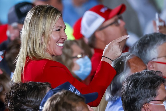 epa08751776 Republican Georgia Congressional candidate and QAnon promoter Marjorie Taylor Greene is recognized by US President Donald J. Trump as he speaks at his Make America Great Again Rally campai ...