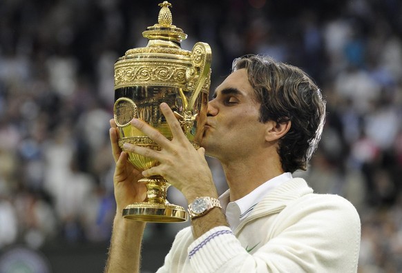 epa03300941 Roger Federer of Switzerland kisses the Championship trophy after defeating Andy Murray of Britain in the men's singles final of the Wimbledon Championships at the All England Lawn Te ...
