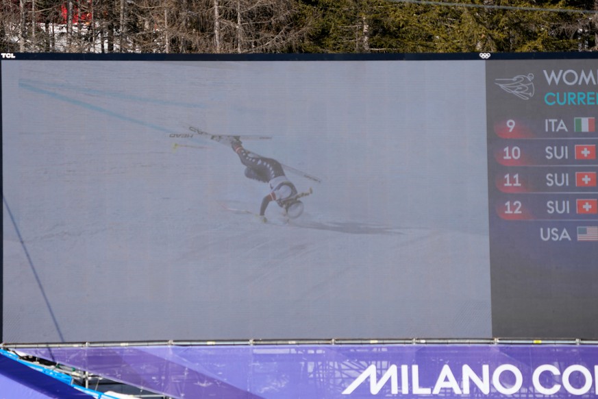 United States' Lindsey Vonn's crash is seen on a giant screen at the finish area of an alpine ski women's downhill race, at the 2026 Winter Olympics, in Cortina d'Ampezzo, Italy, S ...