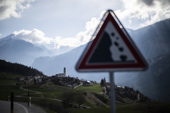 Blick auf das Dorf und ein Schild, das vor Steinschlag warnt, aufgenommen am Dienstag, 4. April 2023, in Brienz-Brinzauls. Ein Teil des Berges bewegt sich immer schneller, wie die Gemeinde mitteilte.  ...