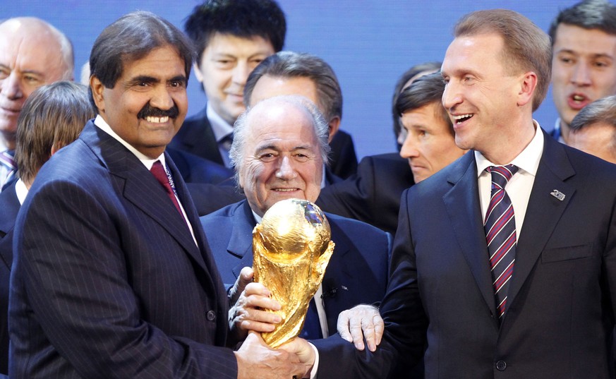 Da haben sie noch gut Lachen: FIFA-Präsident Sepp Blatter wird flankiert vom russischen Premierminister Igor Shuvalov (r.) und Scheich Hamad bin Khalifa Al-Thani, dem Emir von Katar, bei der WM-Bekann ...