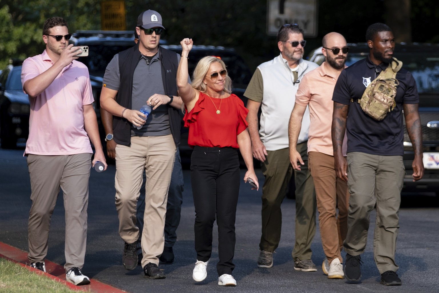 Rep. Marjorie Taylor Greene, R-Ga., cheers supporters of former President Donald Trump as she walks out of the Fulton County Jail parking lot in Atlanta on Thursday, Aug. 24, 2023. (AP Photo/Ben Gray)