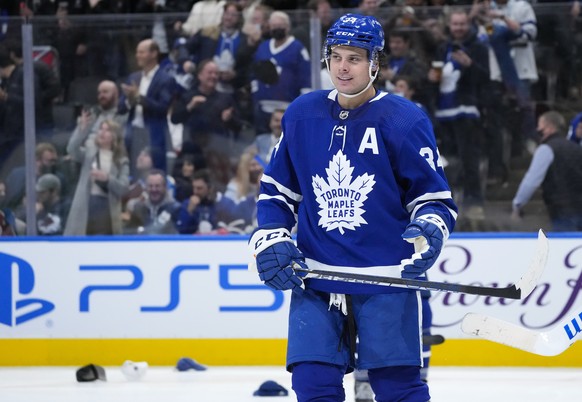 Toronto Maple Leafs forward Auston Matthews smiles after scoring a hat trick, as fans throw hats onto the ice, during the third period of the team&#039;s NHL hockey game against the Colorado Avalanche ...