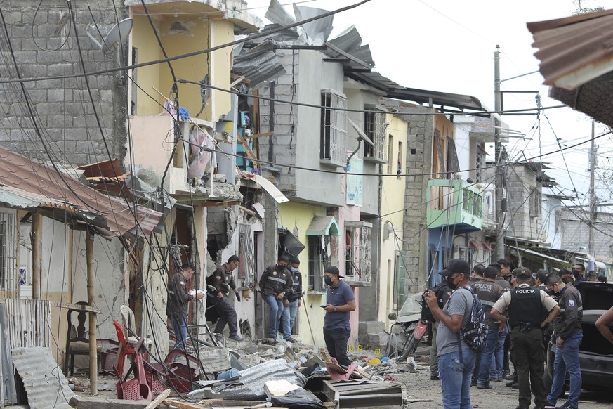 Polizeibeamte vor zerstörten Häuser: Acht wurden bei der Explosion am 14. August 2022 beschädigt.