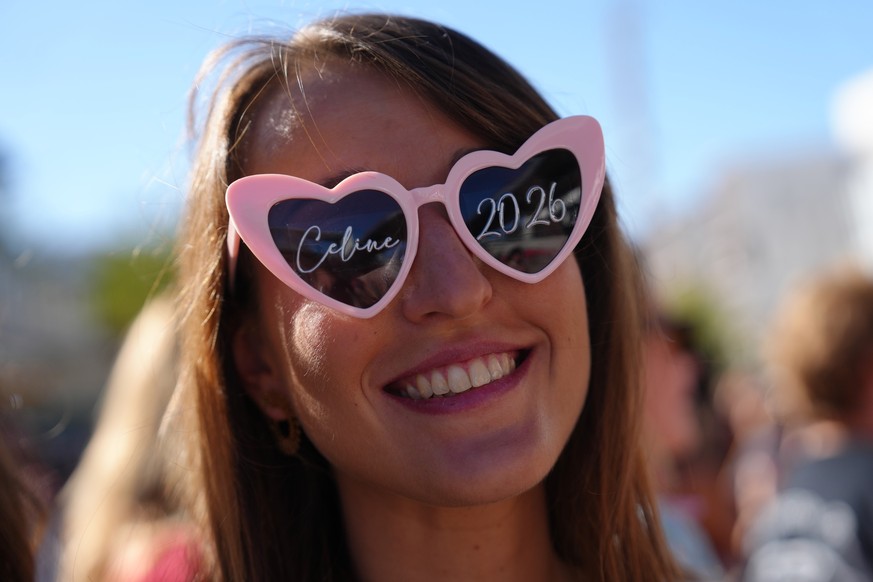 A fan of Celine Dion smiles before the opening concert of the 'Celine Dion Paris 2026' residency at the Plenitude Arena in Nanterre, outside Paris, Saturday, Sept. 12, 2026. (AP Photo/Aureli ...