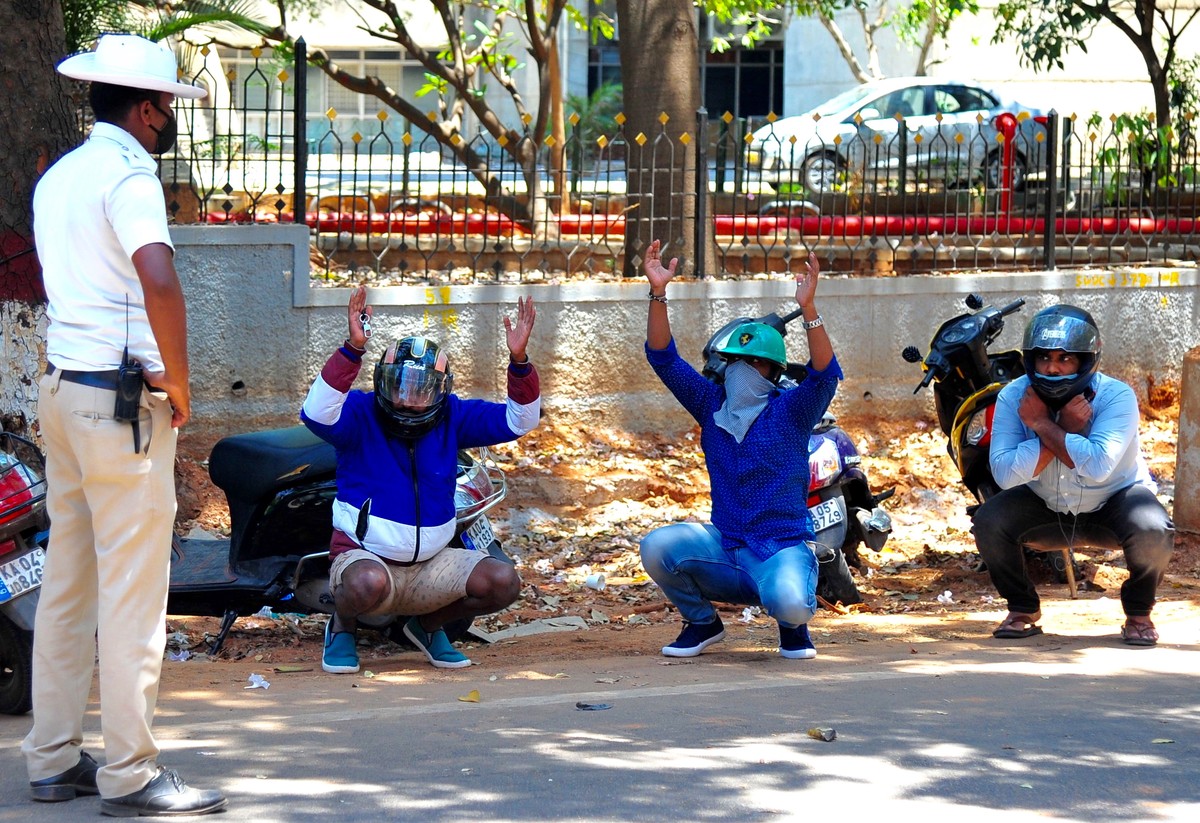 epaselect epa08330002 Indian traffic policeman stops bike riders and imposes punishment on them after they broke the lockdown on the fifth day of nation-wide lockdown as a precaution against the sprea ...