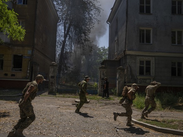 Ukrainian soldiers run after a strike hit a residential area, in Kramatorsk, Donetsk region, eastern Ukraine, Thursday, July 7, 2022. (AP Photo/Nariman El-Mofty)