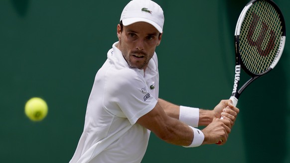 epa07697282 Roberto Bautista Agut of Spain in action against Karen Khachanov of Russia during their third round match at the Wimbledon Championships at the All England Lawn Tennis Club, in London, Bri ...