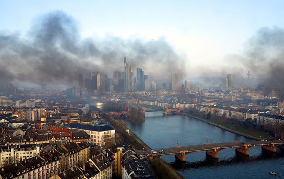 epa04667343 A handout picture made available by www.mainhattan-webcam.de shows black smoke billowing over the skyline of the financial metropolis of Frankfurt, Germany, 18 March 2015. German authoriti ...