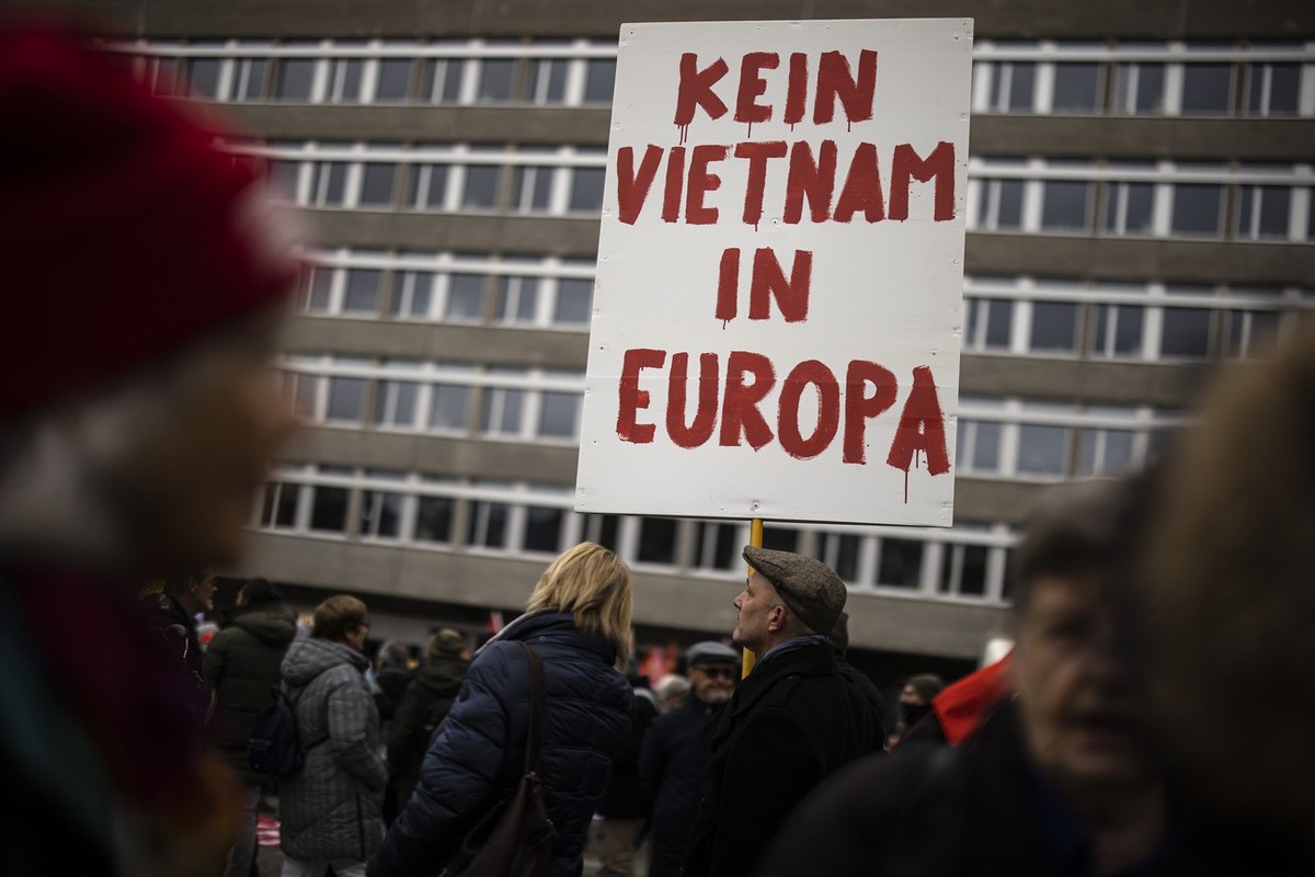 A protestor holds a placard reading "No Vietnam in Europe" as he takes part in a rally marking the first anniversary of Russia's invasion of Ukraine, in Zurich, Switzerland, on Saturday ...