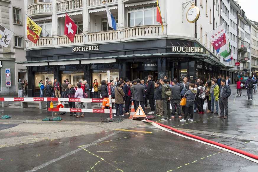 Asiatische Touristen am Schwanenplatz vor dem Uhrengeschaeft Bucherer bei regnerischem Wetter am Donnerstag, 16. Oktober 2014, in Luzern. (KEYSTONE/Sigi Tischler)