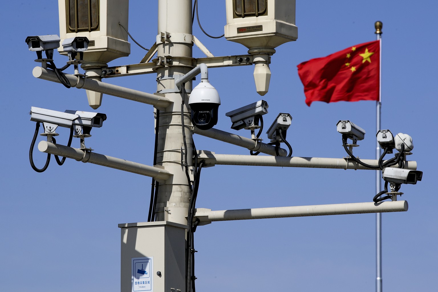 A Chinese national flag flutters near the surveillance cameras mounted on a lamp post in Tiananmen Square in Beijing, Friday, March 15, 2019. Chinese Premier Li Keqiang on Friday denied Beijing tells  ...
