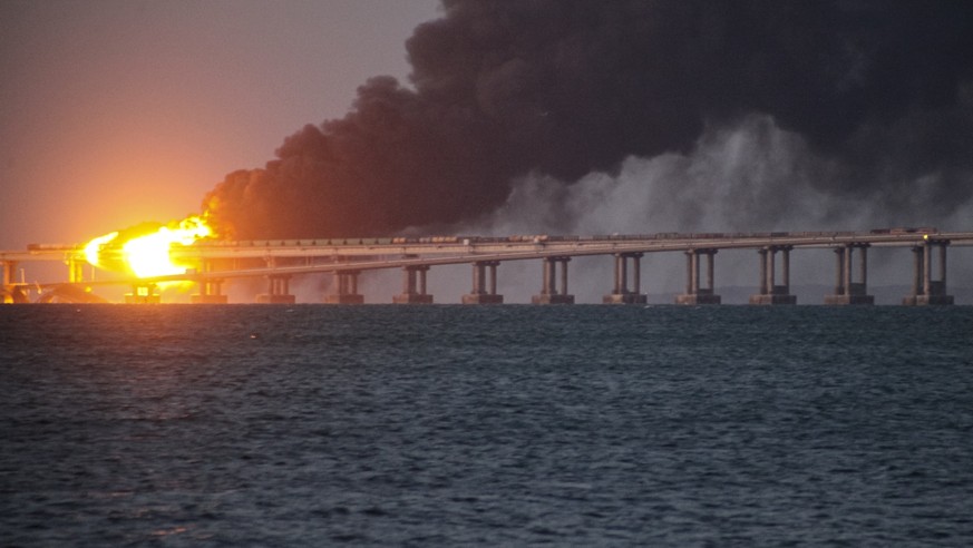 FILE - Flame and smoke rise from the Crimean Bridge connecting Russian mainland and the Crimean peninsula over the Kerch Strait, in Kerch, Crimea, Oct. 8, 2022. Russian authorities say a truck bomb ha ...