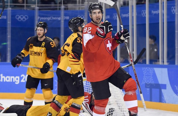 Simon Moser of Switzerland, right, celebrates after scoring 1-1 versus Danny aus den Birken, goalkeeper of Germany, during the men ice hockey play-off qualification match between Switzerland and Germa ...