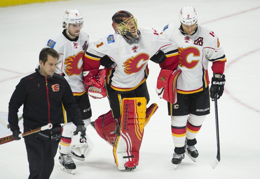 Jonas Hiller muss mit schmerzverzerrtem Gesicht vom Eis geführt werden.