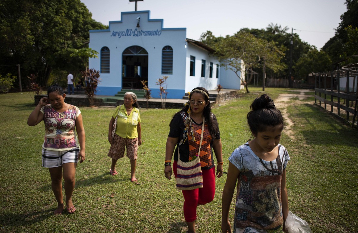 epa07128303 Indigenous educator of the 'Bare' ethinicity Ana Claudia Martins Tomas (2R), 40, whose indigenous name is 'Suri', heads to a polling station at the rural community of & ...