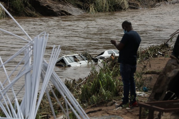 epa09886248 Two cars are submerged in flood waters near Durban, South Africa, 12 April 2022. At least 45 people have died as a result of heavy flooding in the Eastern Coastal area. Key roads in the ar ...