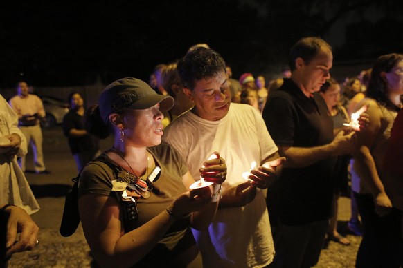 During a candlelight vigil Jacqueline Melendez, left, and her husband Jose Melendez mourn the death of three victims who were killed in the recent shootings in the Seminole Heights neighborhood in Tam ...