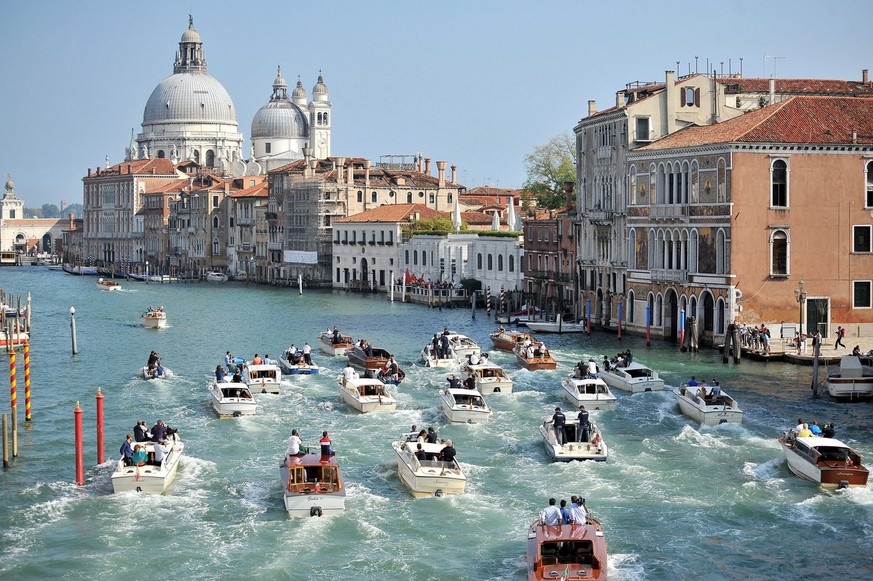 The boat carrying George Clooney and his wife Amal Alamuddin, is surrounded by media and security boats as they cruise the Grand Canal after leaving the Aman luxury Hotel in Venice, Italy, Sunday, Sep ...