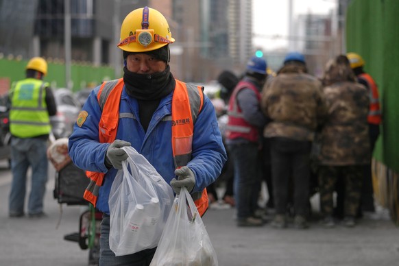Construction workers buy their lunch meals near the office buildings at the central business district during lunch break hour in Beijing, Monday, Jan. 19, 2026. (AP Photo/Andy Wong)
China Economy