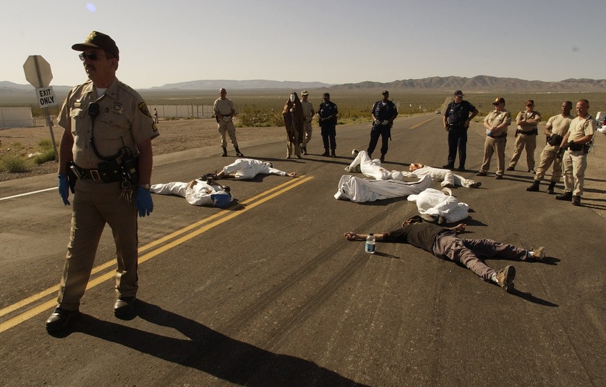 FILE - In this May 11, 2003, file photo, protesters lie on the pavement opposed to the proposed Yucca Mountain nuclear storage facility and weapons testing after crossing the line into the Nevada Test ...