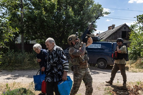 White Angels police unit evacuates civilians from Druzhkivka DRUZHKIVKA, UKRAINE - JULY 03: White Angels police unit look to the sky for Russian drones and point their guns to the sky as they evacuate ...