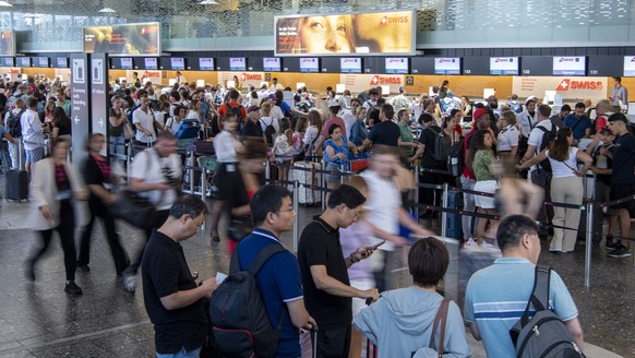 epa10747425 People line up in long queues as they wait in front of the check-in counters to be processed on their way to their holiday destinations, at the airport in Zurich, Switzerland, 15 July 2023 ...