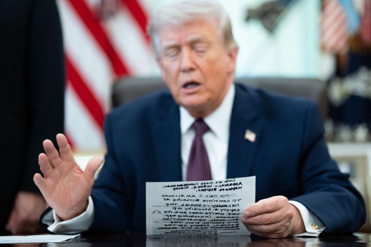 epa12863104 US President Donald J Trump references his notes during an executive order signing event in the Oval Office of the White House in Washington, DC, USA, 31 March 2026. The order directs the  ...