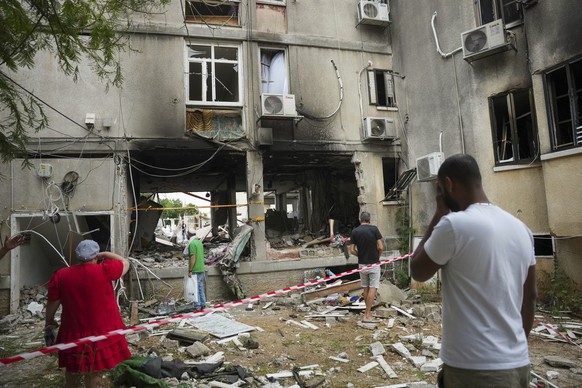 Israelis inspect a damaged residential building after it was hit by a rocket fired from the Gaza Strip, in Ashkelon, Israel, Monday, Oct. 9, 2023. The militant Hamas rulers of the Gaza Strip carried o ...