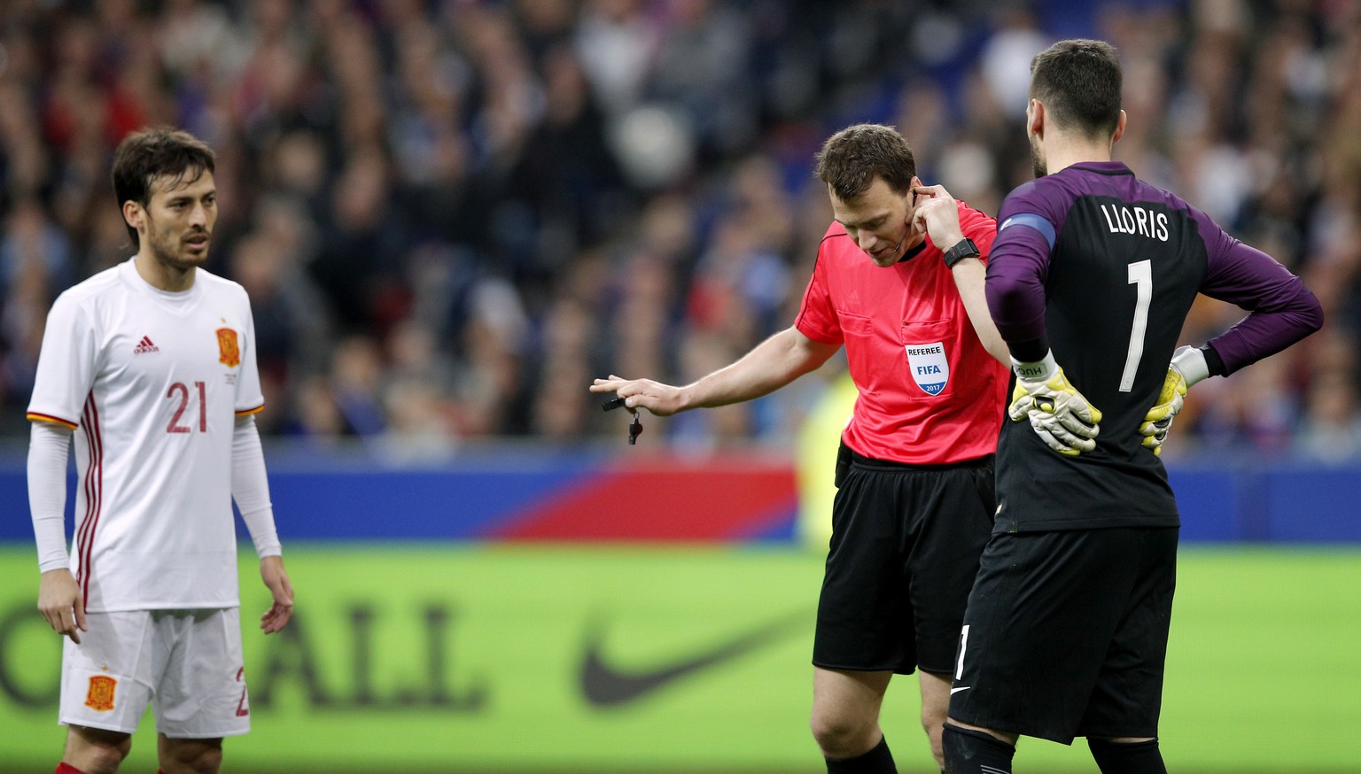 Spain&#039;s scorer David Silva, left, looks on as Referee Felix Zwayer, center, from Germany holds his earphone during the international friendly soccer match between France and Spain at the Stade de ...