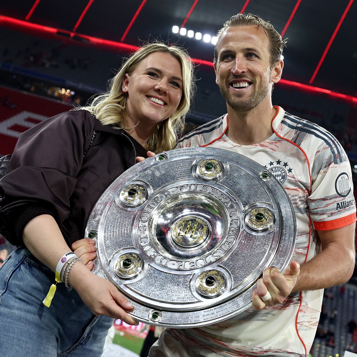 epa12089823 Harry Kane of Bayern Munich (R) celebrates the German Bundesliga championship title with his wife Katie Goodland (L) after the German Bundesliga soccer match between FC Bayern Munich and B ...