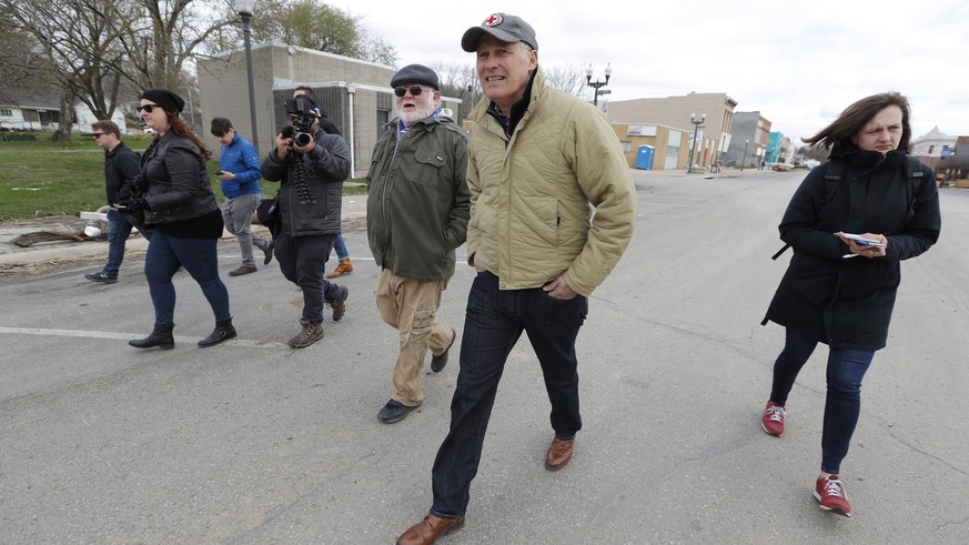 2020 Democratic presidential candidate Washington Gov. Jay Inslee, center, tours flood damage, Friday, April 12, 2019, in Hamburg, Iowa. (AP Photo/Charlie Neibergall)