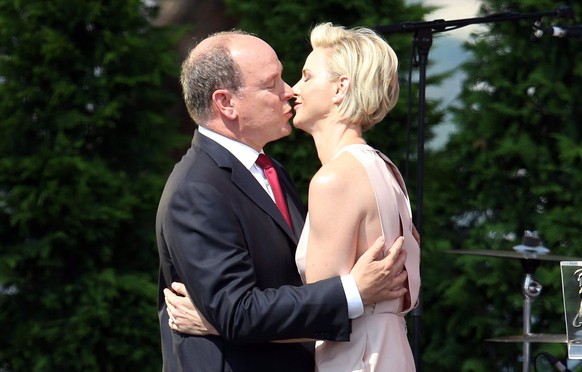epa04842664 Prince Albert II of Monaco (L) and his wife, Princess Charlene of Monaco kiss during the celebrations to mark Prince Albert II&#039;s decade on the throne at the Royal Palace in Monaco, 11 ...